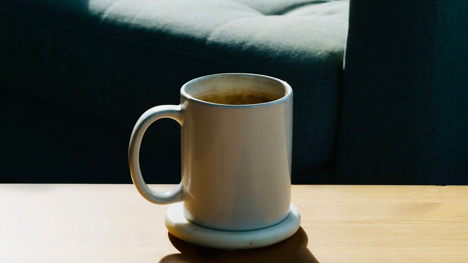 Sunlight on a white mug on a wooden table