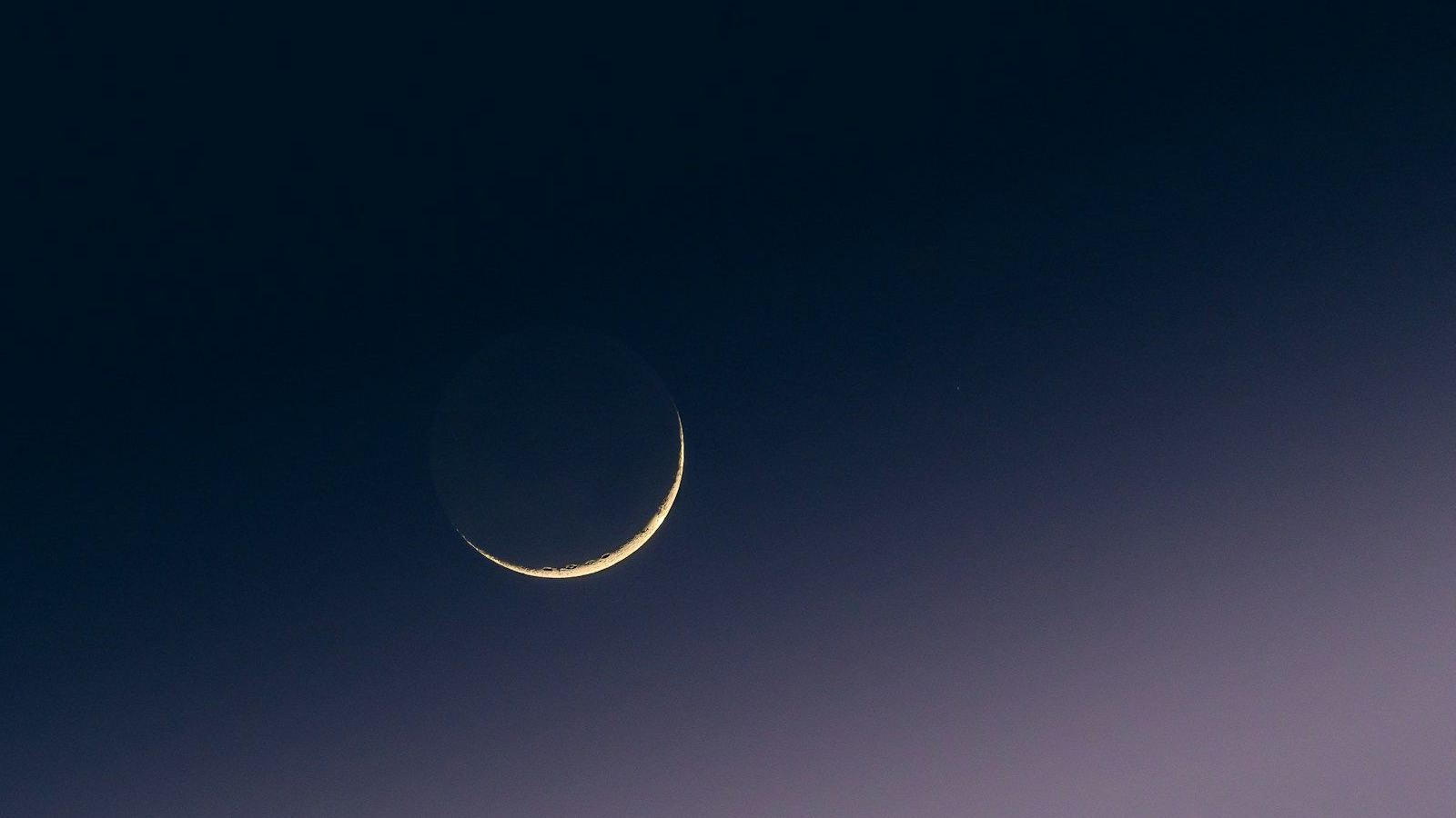 A crescent moon in the evening sky