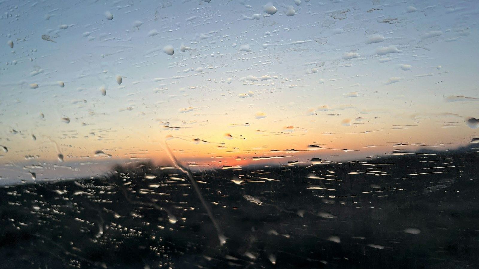 Raindrops on a window at sunset
